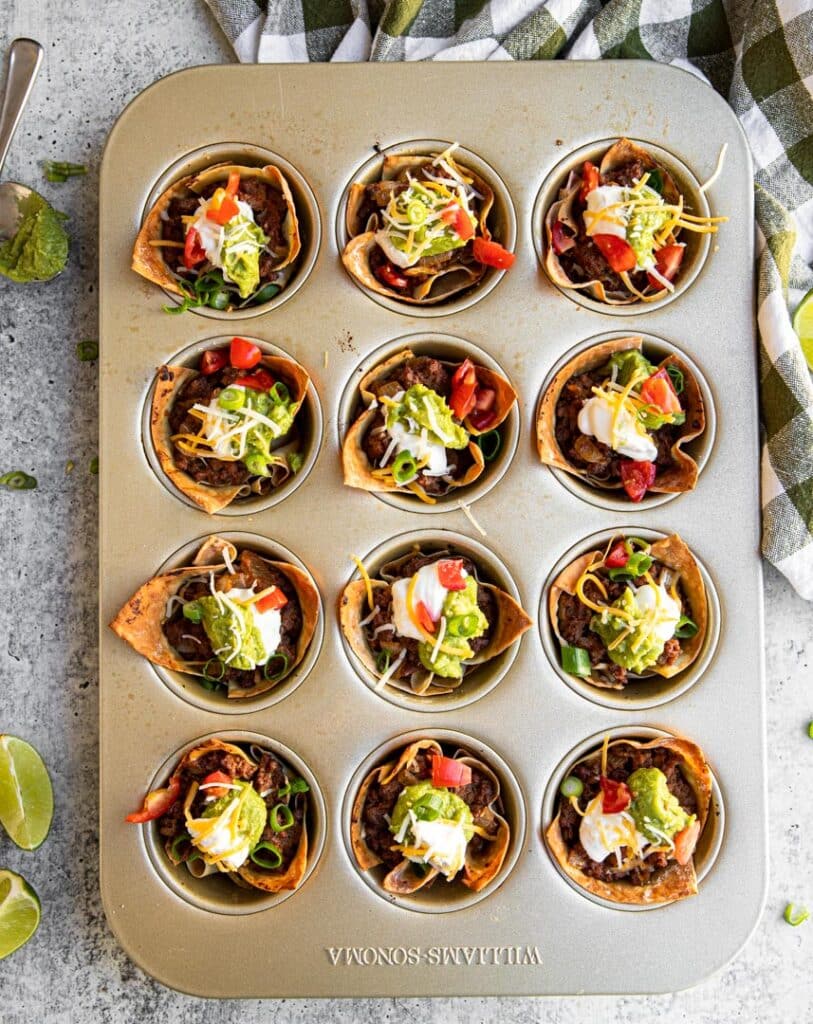 checkered towel, limes, guacamole, taco cups, muffin tin, taco meat