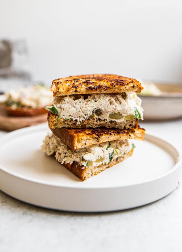 A dill pickle chicken salad sandwich on a plate.  